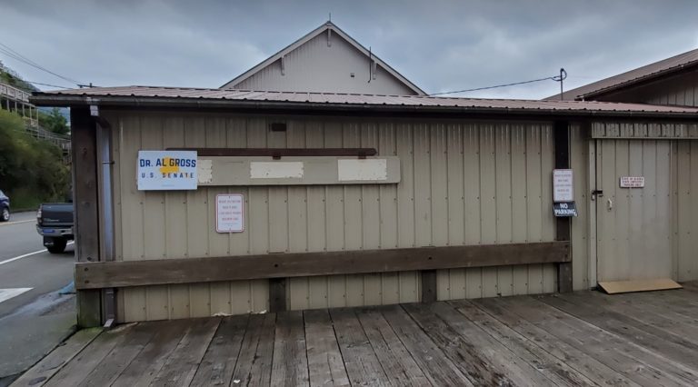 Al Gross screws campaign sign on side of State storage building in Ketchikan