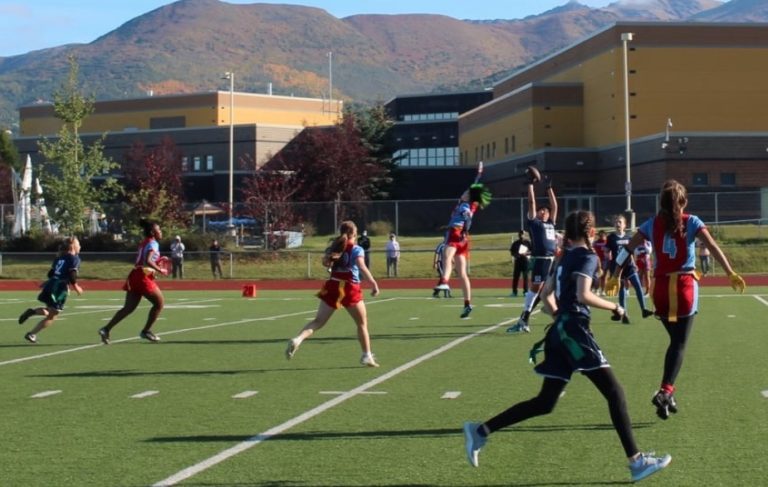 East High School girls flag football team members take a knee during National Anthem … on 9-11